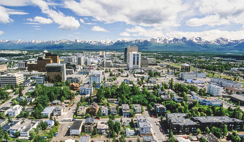 Aerial view of Anchorage, Alaska with mountains in the background.