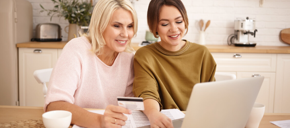 Older woman and adult daughter shop online.
