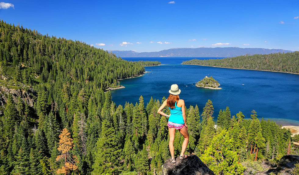 Woman hiker looks at out beautiful Lake Tahoe view.