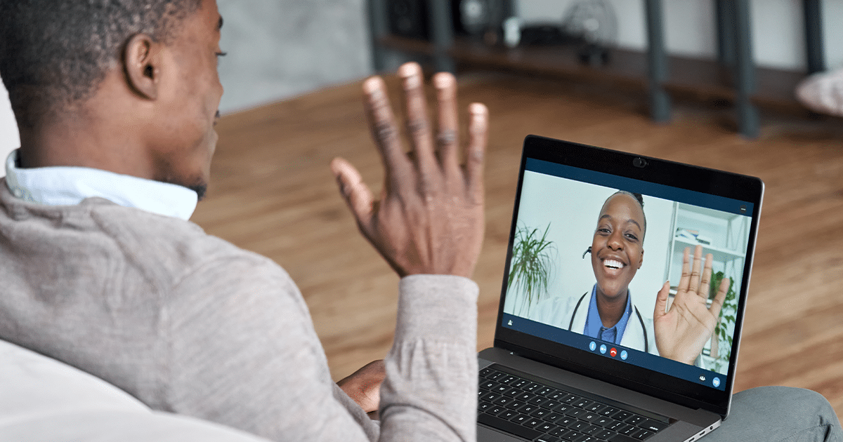 Man waving hello to doctor during a telehealth visit.