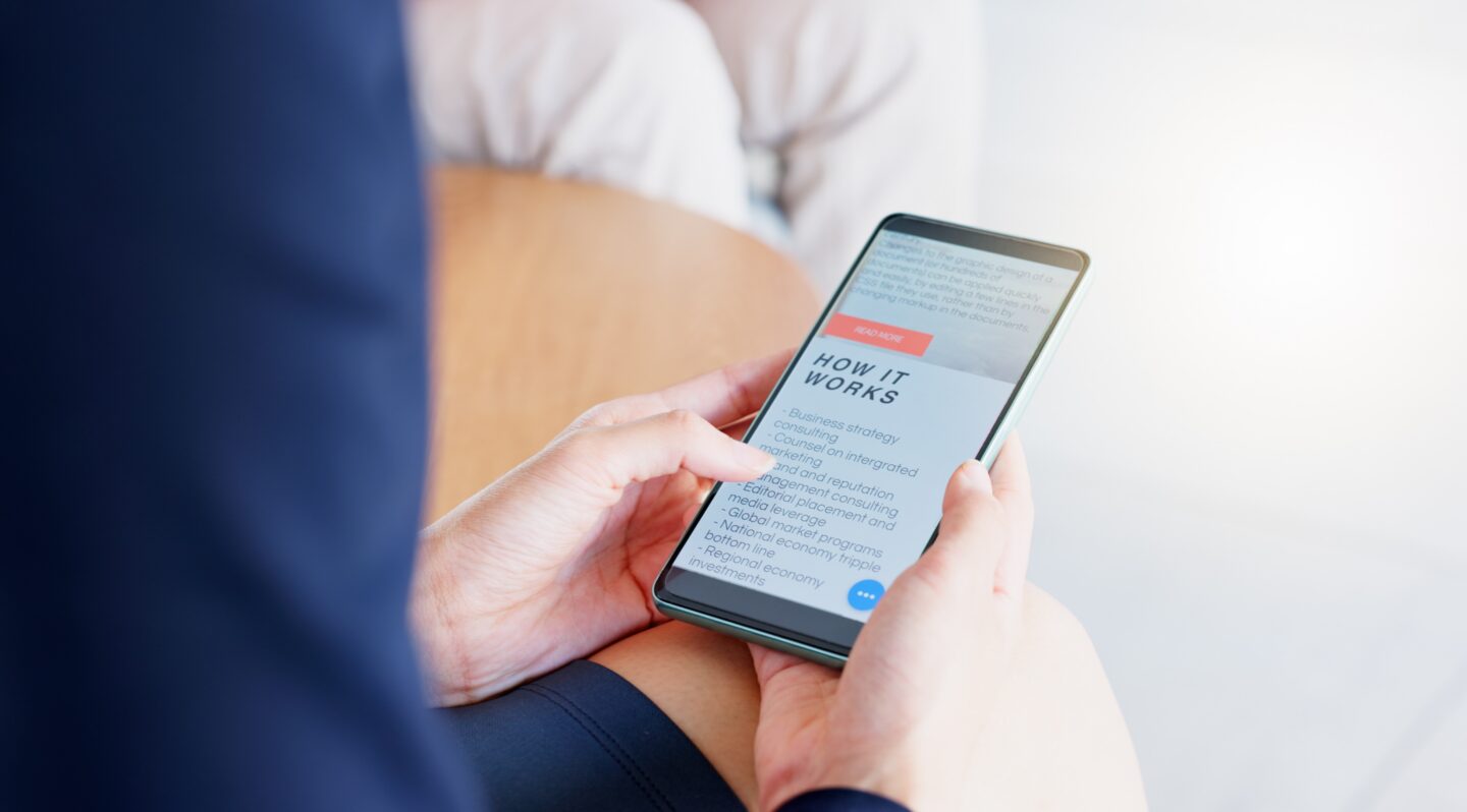Hands holding a phone with "how it works" on the screen.